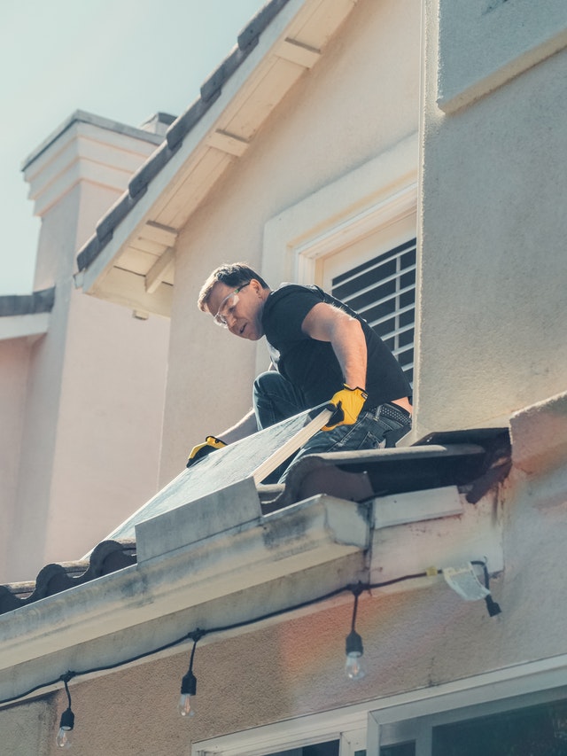 A man fixing a roof, representing the importance of roof inspection prior to buying a home