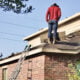 Why Fall is the Best Season for a Roof Replacement? A man standing on a roof that needs replacement