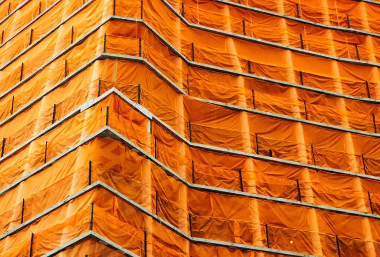 A roof covered in an orange tarp.