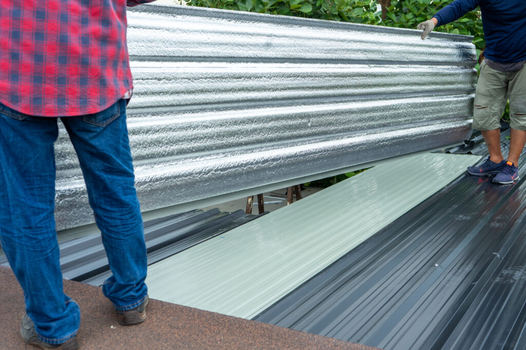 Elevate your property: unmatched expertise with all types of metal roofs in minneapolis: a roofer standing on a metal roof using various styes of metal roofing material